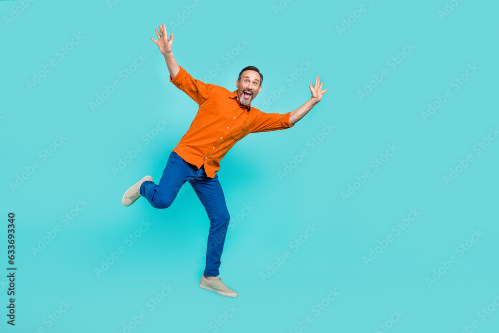 Full body length photo of funky jumping carefree overjoyed businessman positive crazy mood isolated on aquamarine color background