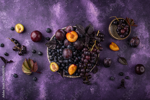 Assortment of purple fruit plum, grape, blueberry and basil