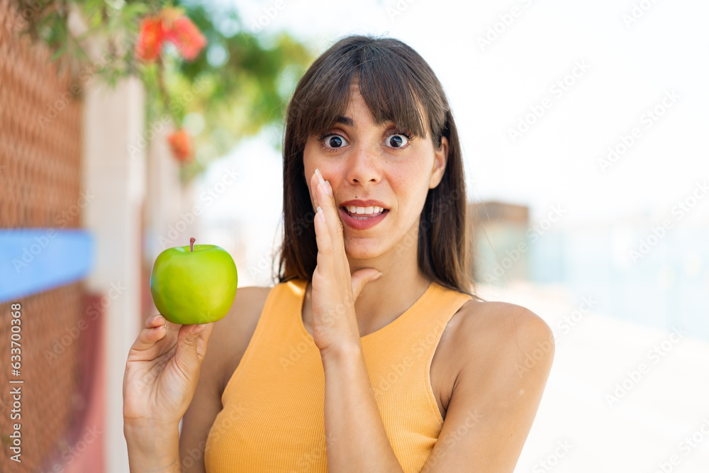 Young woman with an apple at outdoors whispering something Young woman with an apple at outdoors whispering something
