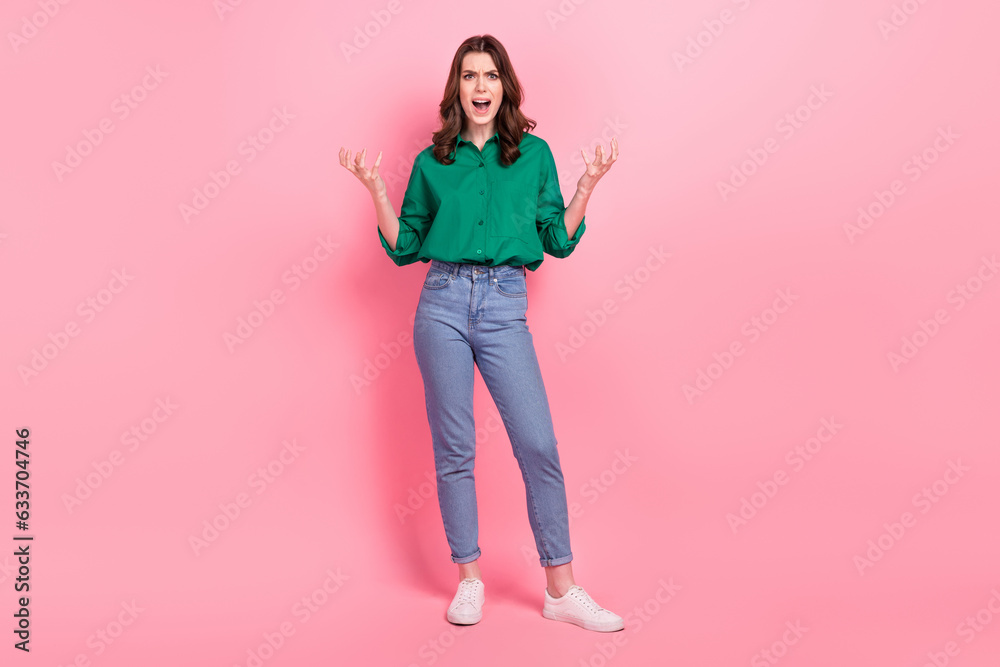 Full length photo of furious aggressive lady wear green shirt shouting rising arms hands isolated pink color background