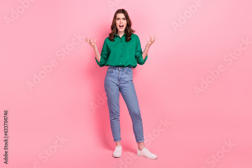Full length photo of furious aggressive lady wear green shirt shouting rising arms hands isolated pink color background