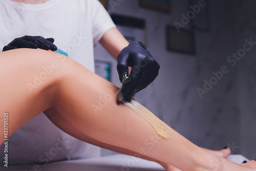 Sugaring: epilation with liquate sugar at legs. photo