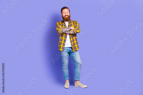 Full body portrait of confident attractive bearded guy hipster hold arms folded wear casual outfit isolated purple color background © deagreez