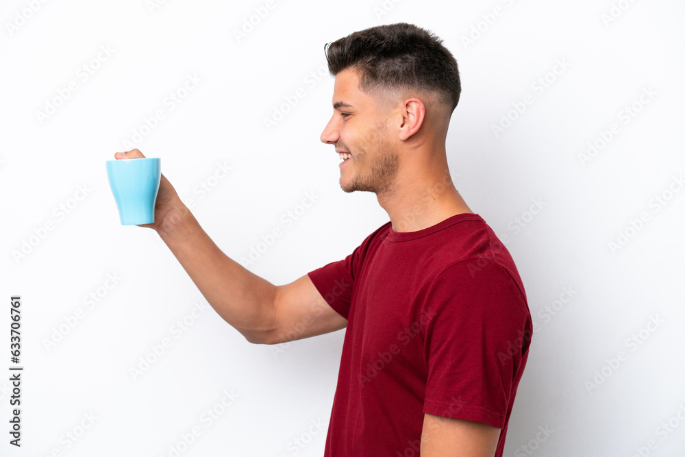Young caucasian man holding cup of coffee isolated on white background with happy expression Young caucasian man holding cup of coffee isolated on white background with happy expression