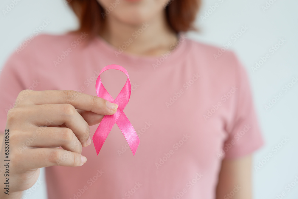 Woman hold pink ribbon breast cancer awareness. Female health check consciousness. international Women Day and World Cancer Day. sign cancer, Symbolic, health care, support patients, timely diagnosis Woman hold pink ribbon breast cancer awareness. Female health check consciousness. international Women Day and World Cancer Day. sign cancer, Symbolic, health care, support patients, timely diagnosis