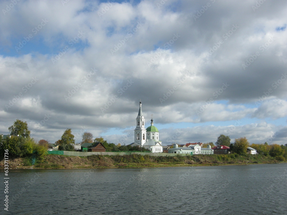 landscape with a river and a church with expressive cumulus clouds