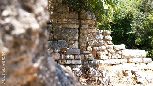 Butrint, Albania, a stone wall of ancient ruins bathed in the light of a hot day photo
