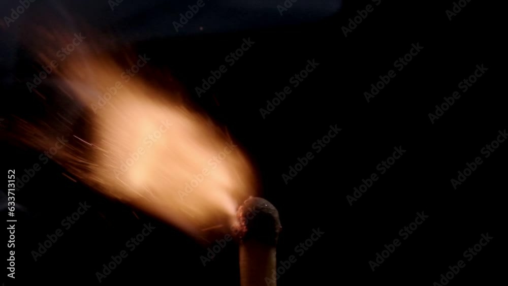 A mesmerizing close-up video captures the slow-motion ignition of a single matchstick against a stark black background, highlighting the intricate dance of flames and sparks.