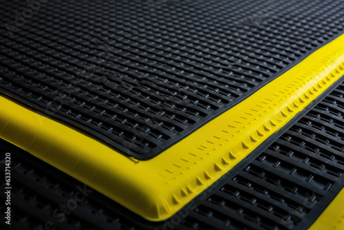 Macro shot of a safety mat with a bright yellow border for high visibility and safety in industrial settings