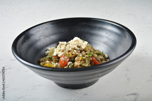 trio quinoa grain salad bowl with avocado, tomato, pea bean, carrot and brown rice in black bowl on white marble table background chef cook healthy poke bowl halal vegan food menu