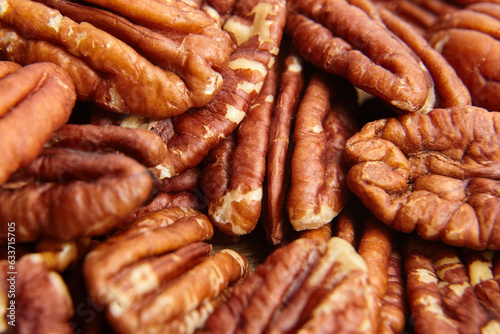 Pecan nuts kernel texture background closeup. Heap of peeled pecan halves. The background showcases pecans rustic charm