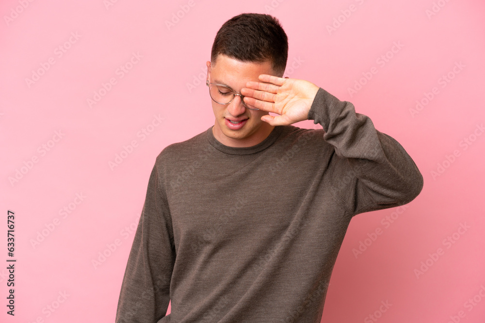 Young Brazilian man isolated on pink background with tired and sick expression
