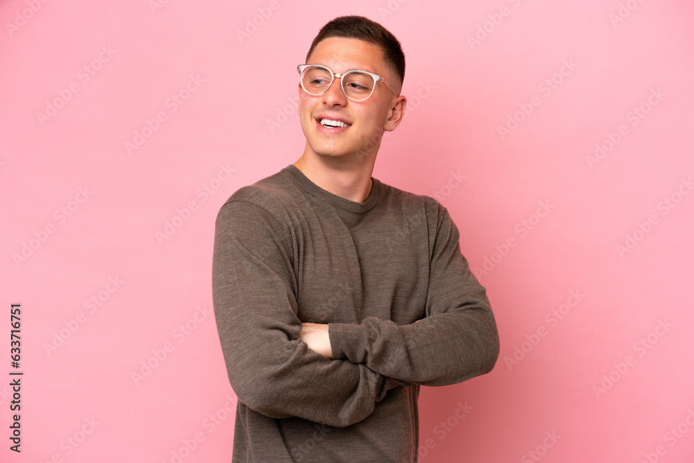 Young Brazilian man isolated on pink background with arms crossed and happy Young Brazilian man isolated on pink background with arms crossed and happy