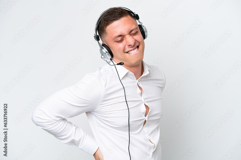Telemarketer Brazilian man working with a headset isolated on white background suffering from backache for having made an effort Telemarketer Brazilian man working with a headset isolated on white background suffering from backache for having made an effort