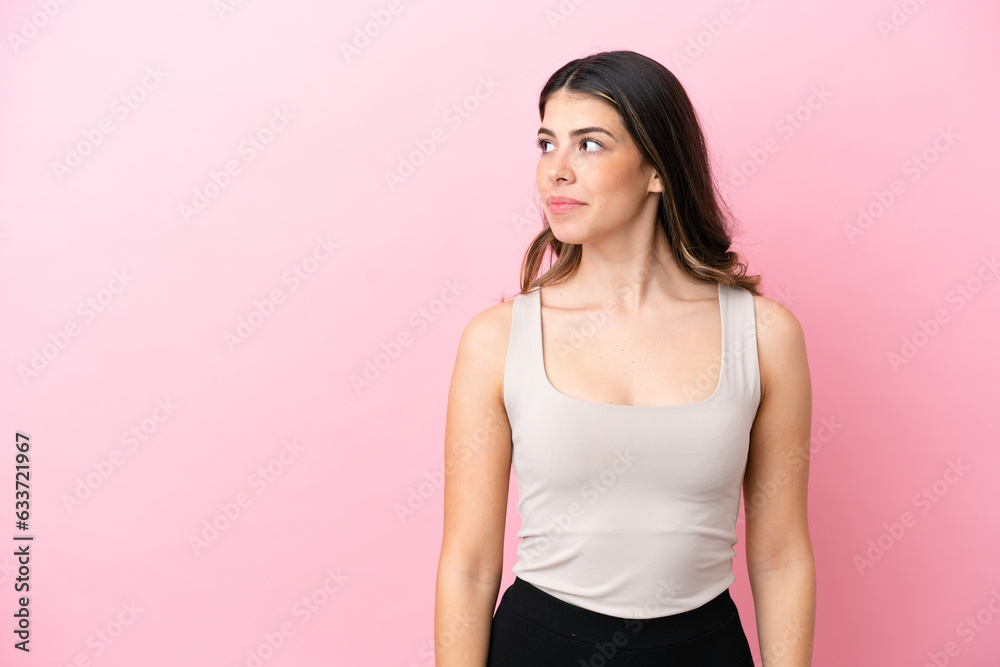 Young Italian woman isolated on pink background looking to the side Young Italian woman isolated on pink background looking to the side