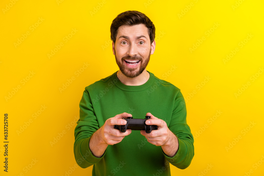 Photo of addicted gamer young guy brunet holding wireless joystick new console playstation 5 advert isolated on yellow color background Photo of addicted gamer young guy brunet holding wireless joystick new console playstation 5 advert isolated on yellow color background