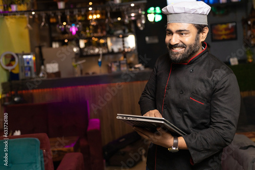 Waiter using tablet at restaurant.