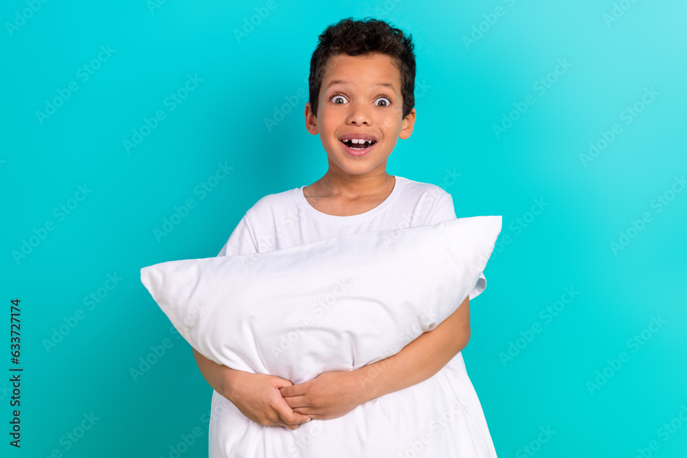 Photo of cheerful astonished little boy open mouth arms hold comfy pillow cushion isolated on teal color background Photo of cheerful astonished little boy open mouth arms hold comfy pillow cushion isolated on teal color background
