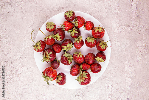 Frech ripe strawberries 0n white blate over on gray concrete background. photo