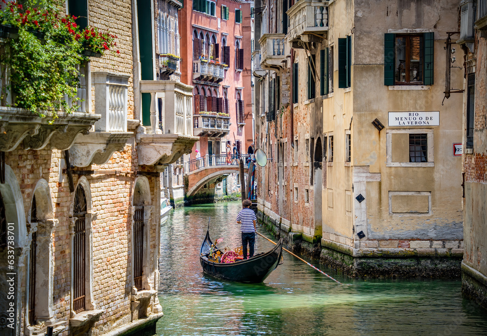 Traditional gondola ride on the narrow water canals.Tourists in Venice.