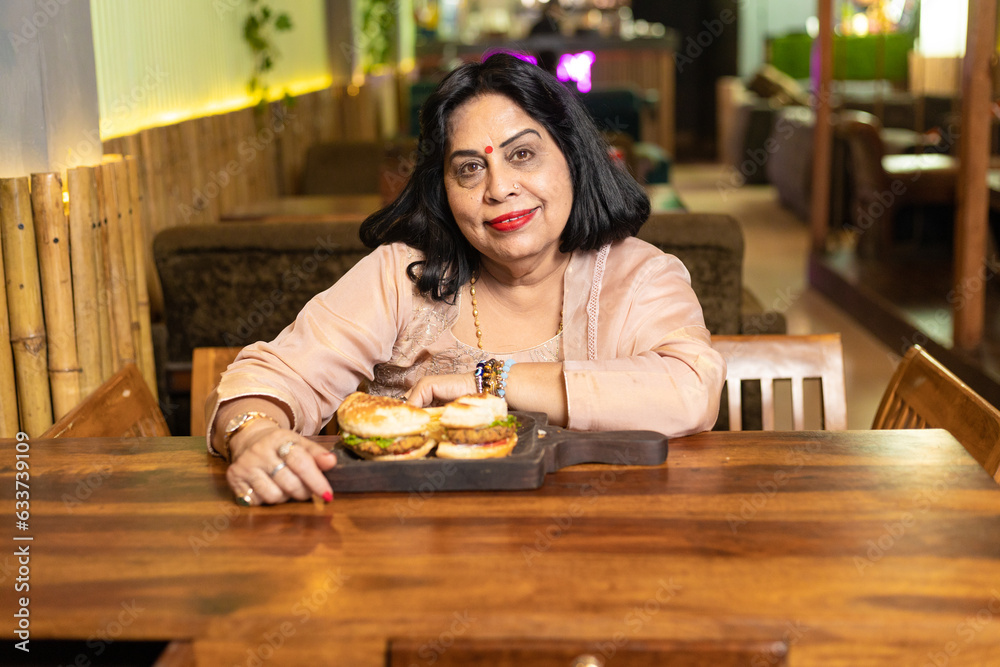 Senior woman sitting, food arrange in front of table at restaurant Senior woman sitting, food arrange in front of table at restaurant