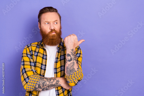 Photo of minded doubtful person look indicate thumb finger empty space isolated on violet color background