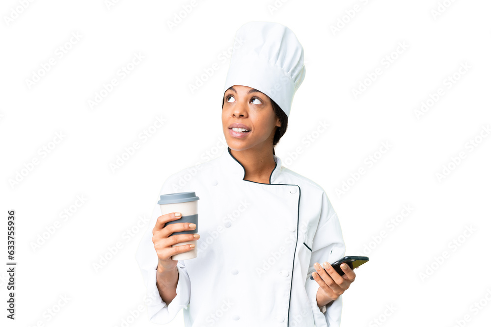 Young African American chef over isolated chroma key background holding coffee to take away and a mobile while thinking something Young African American chef over isolated chroma key background holding coffee to take away and a mobile while thinking something
