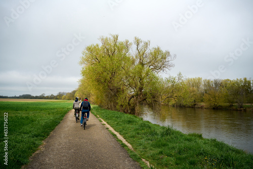 two people riding bicycle by river in Val de Cher in France in the spring