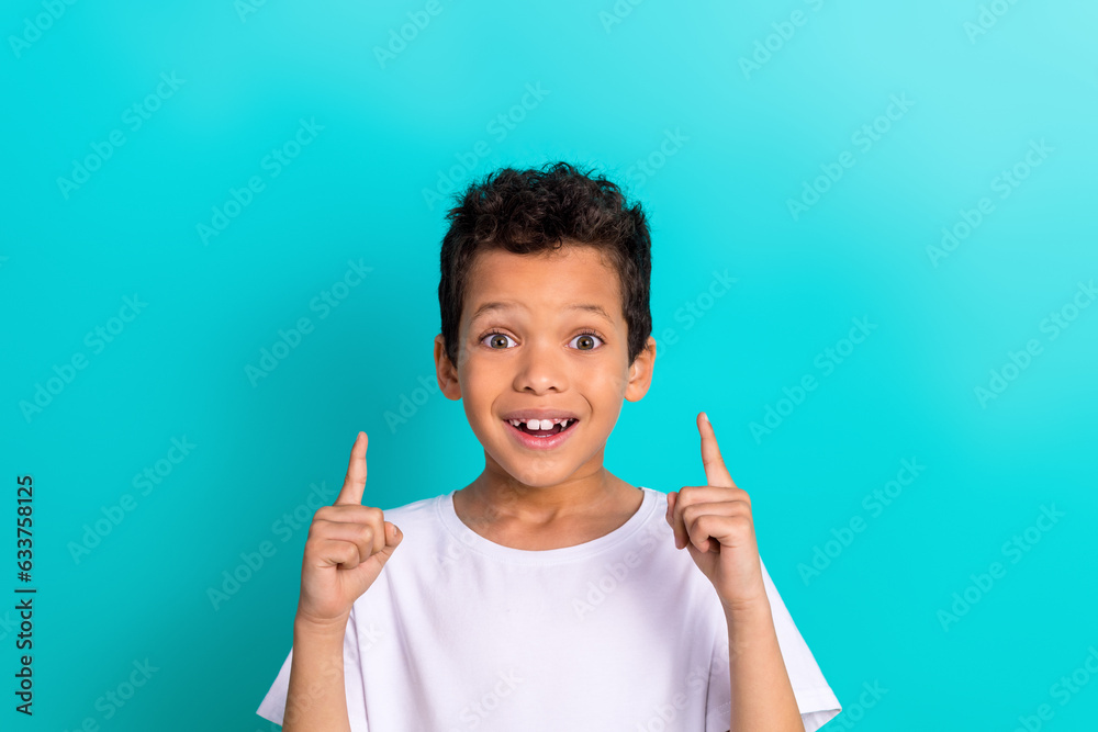 Photo of astonished preteen age boy wear stylish white clothes two arm presenting empty space cool offer isolated on cyan color background Photo of astonished preteen age boy wear stylish white clothes two arm presenting empty space cool offer isolated on cyan color background