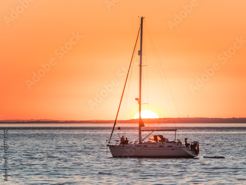 Setting sun behind a yacht