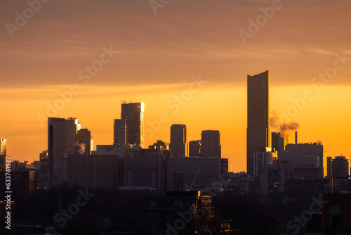 Downtown Toronto skyline at sunrise, with golden light illuminating the sky and sides of buildings