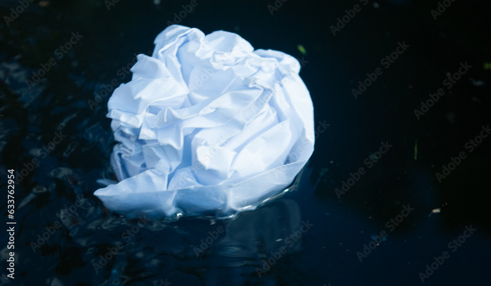 Fototapeta premium A lump of paper floats in the water