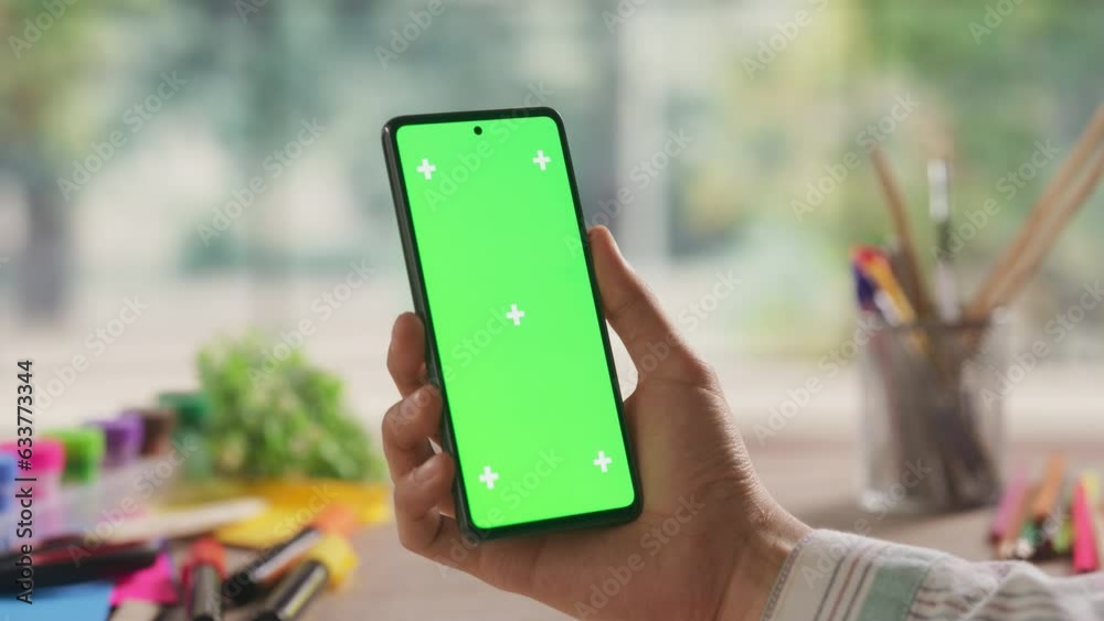 Illustrator Holding a Smartphone Device, Looking at a Screen with Green Chromakey Mock Up Display. Video Template with for Digital Marketing, Creative Design Demo, Advertising Campaign