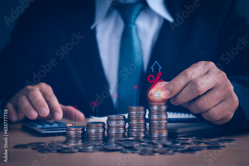 financial planner holding coins and financial growth arrows on wooden table, concept savings and banking interest, inflation, dividends on stock market and digital assets