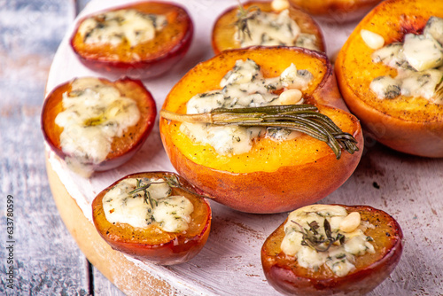 Grilled baked peach and plums stuffed with blue cheese dorblu and rosemary. © twomeerkats