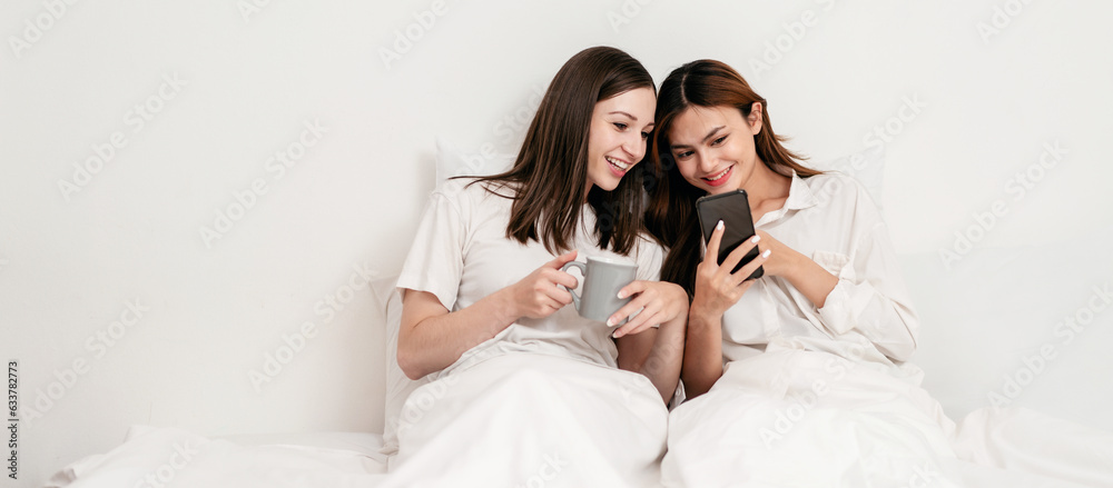 Young asian couple woman using smartphone to surfing internet together and drinking hot chocolate while