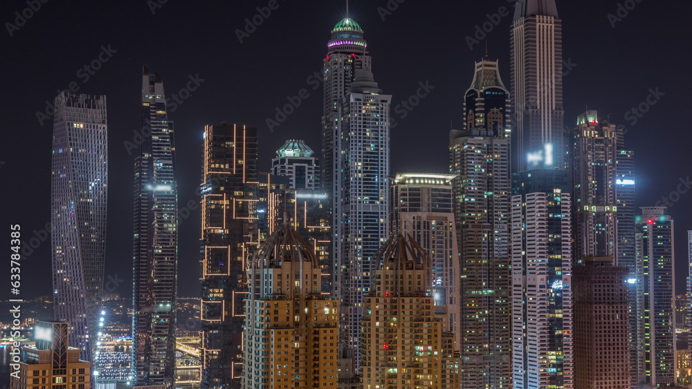 Fototapeta Skyscrapers of Dubai Marina near Sheikh Zayed Road with highest residential buildings all night timelapse