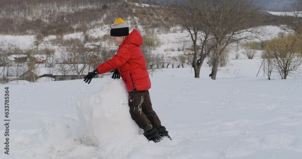 Boy crashes into snowman and breaks it. Child destroys big snowman and has fun. Winter holidays Boy crashes into snowman and breaks it. Child destroys big snowman and has fun. Winter holidays