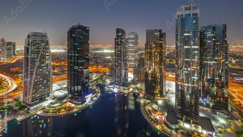 Tall residential buildings at JLT aerial day to night timelapse, part of the Dubai multi commodities centre mixed-use district.