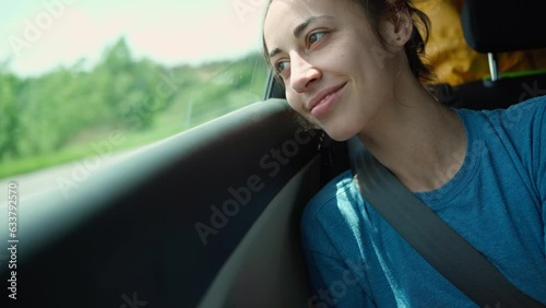 happy laughing young woman hipster in car during car travel with friends. wunderlast and journey, adventure summer vacation. long road passenger. itting in rear seat and having fun on a road trip. photo