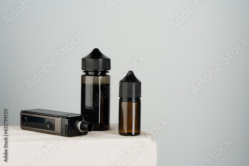 Vaping refill liquid bottle against gray background photo