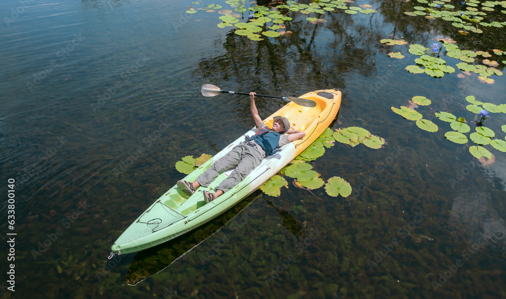Asian man rowing a boat on a river in the Asian forest Lie down and relax peacefully. Asian man rowing a boat on a river in the Asian forest Lie down and relax peacefully.