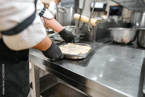 Chef cooking food at restaurant kitchen close up