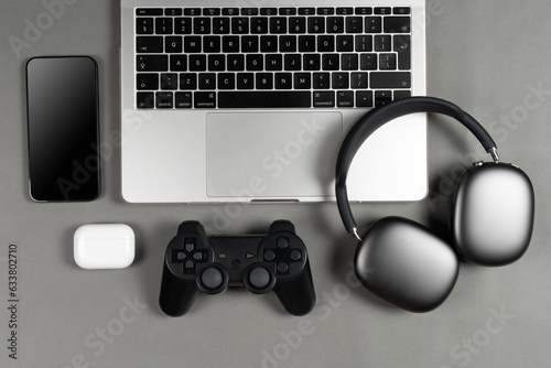 Mockup set of modern gadgets on a beautiful sky blue or blue background with headphones, laptop, phone, joystick and camera
