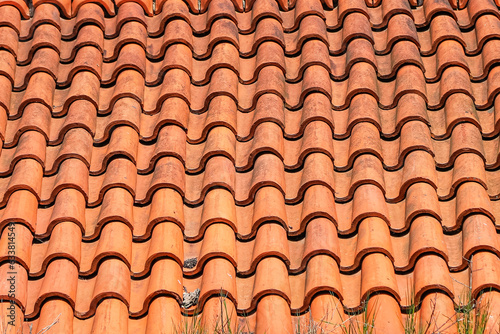 Old roof tiled with S-shaped clay tiles. Photo in perspective with selective focus