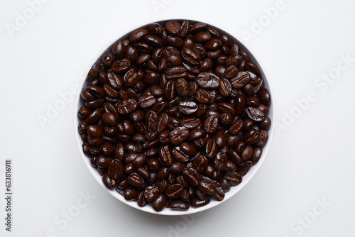 roased coffee beans in bowl on white background. Still Photo photo