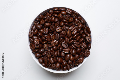 roased coffee beans in bowl on white background. Still Photo photo