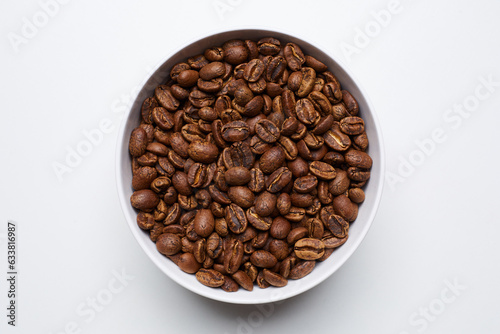 roased coffee beans in bowl on white background. Still Photo