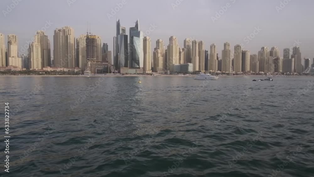 View from a private yacht of a passing jet against the backdrop of Dubai's skyscrapers