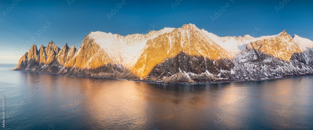 Midnight sun in Northern Norway.
Amazing sunset over calm waters of Norwegian nortern fjords tucked away among hills. Viewpoint, Senja island. Tourism, travel concept.